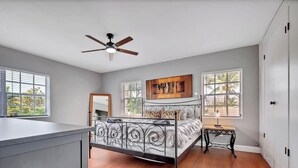 A bedroom with a bed, a ceiling fan, a window, and a painting on the wall. - 2-Home Compound with Pool and BBQ, Sleeps 16 (Miami)