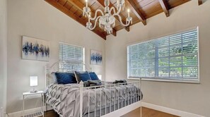 A bedroom with a bed, bedside tables, a chandelier, and artwork on the walls. - 2-Home Compound with Pool and BBQ, Sleeps 16 (Miami)