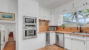A kitchen with white cabinetry, a microwave, an oven, and a sink. - 2-Home Compound with Pool and BBQ, Sleeps 16 (Miami)