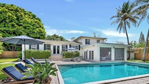 A residential property with a swimming pool, lounge chairs, and a patio area. - 2-Home Compound with Pool and BBQ, Sleeps 16 (Miami)