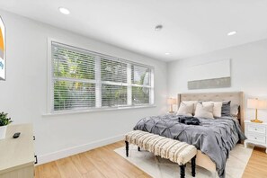 A bedroom with a bed, bedside tables, a bench, and a window with blinds. - Gated Miami Luxury Oasis Pool & BBQ I 4-Bed, 4-Bath (Miami)