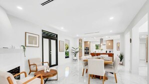 A modern interior with a dining area, kitchen, and seating space. - Gated Miami Luxury Oasis Pool & BBQ I 4-Bed, 4-Bath (Miami)