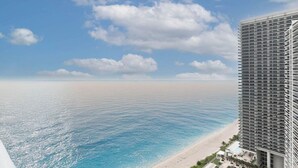 Un hotel moderno con vistas a la playa, una piscina y cielo despejado.