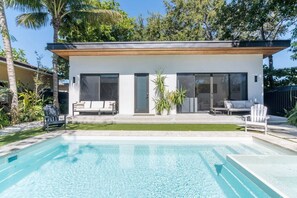 A modern house with a swimming pool, large windows, and outdoor seating. - Luxury Miami Oasis Heated Pool & BBQ with Guesthouse (Miami)