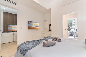 A modern bedroom with a bed, a TV, a dresser, and a view of the outside. - Luxury Miami Oasis Heated Pool & BBQ with Guesthouse (Miami)