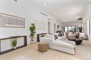 A modern living room with a sofa set, a coffee table, and a potted plant. - Luxury Miami Oasis Heated Pool & BBQ with Guesthouse (Miami)