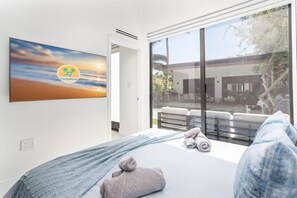 Ein Schlafzimmer mit einem Bett, einem Fenster und einem Gemälde.