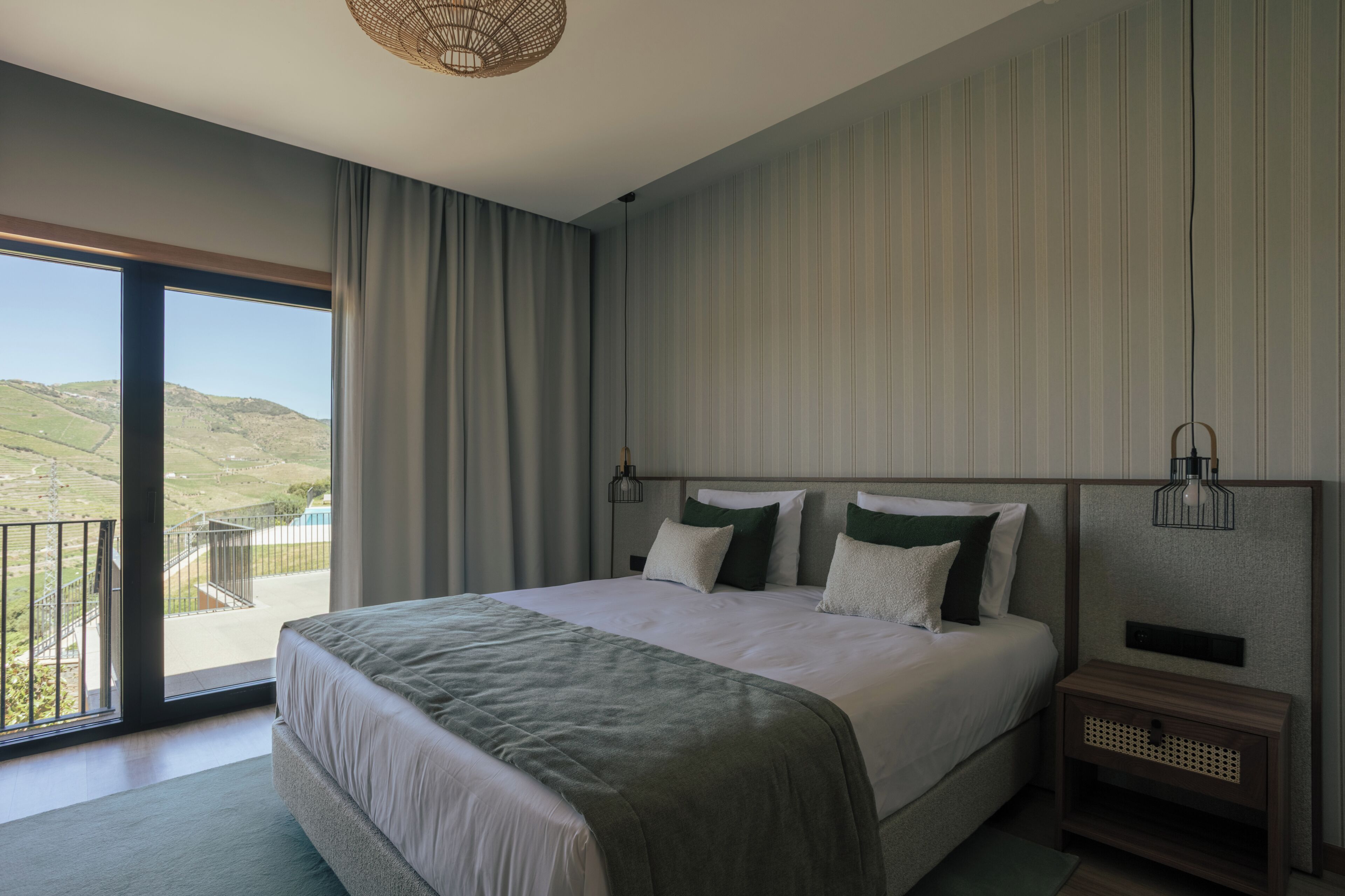 Un dormitorio con una cama grande, vistas al campo y un balcón.