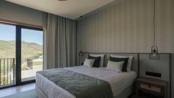 Un dormitorio con una cama grande, vistas al campo y un balcón.