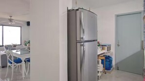 A kitchen with a stainless steel refrigerator, a microwave, and a water dispenser on the counter. - Beachfront Apartment | Ground Floor and Pool (Progreso)