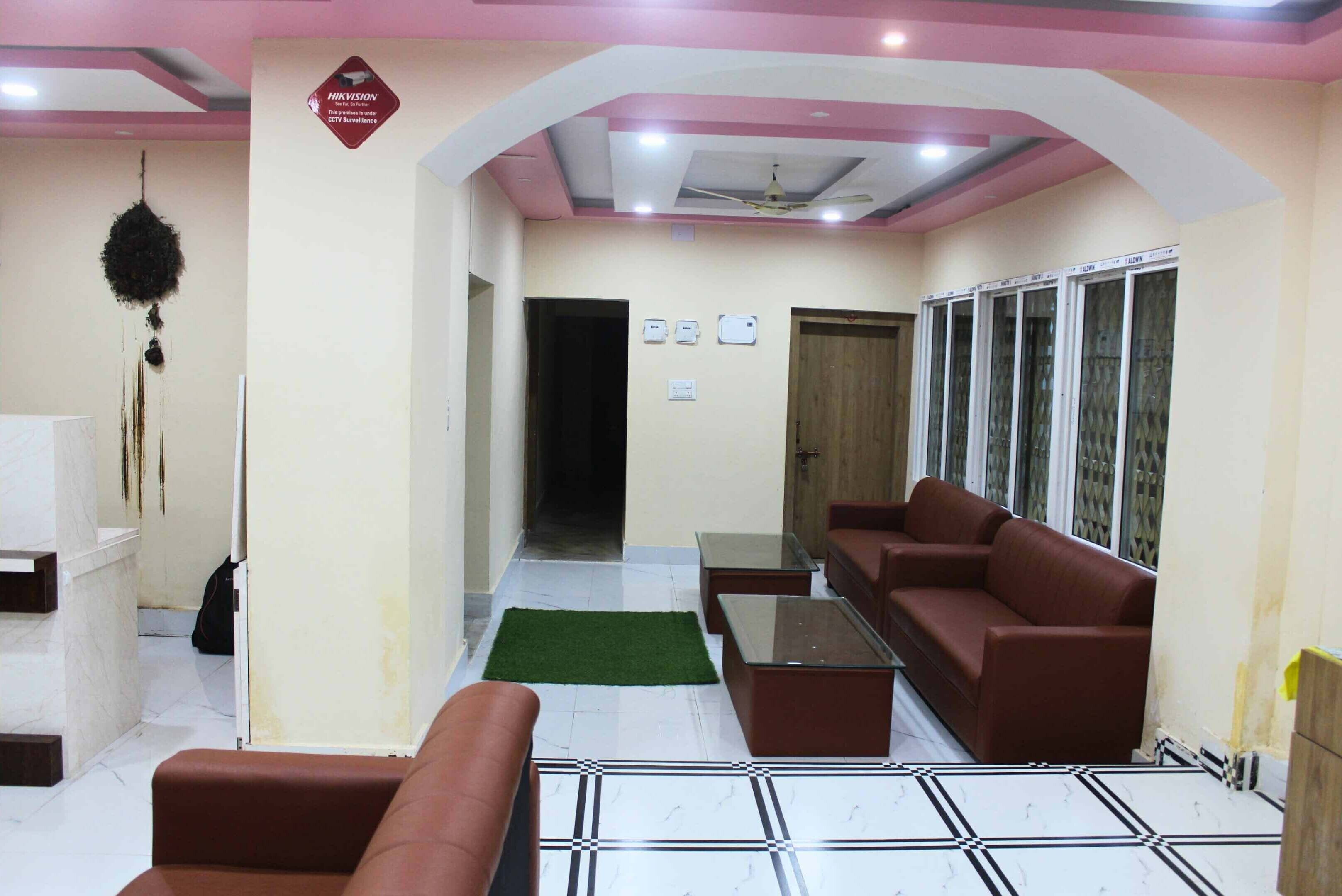 A lobby with a reception desk, seating area, and a staircase leading to other floors.
