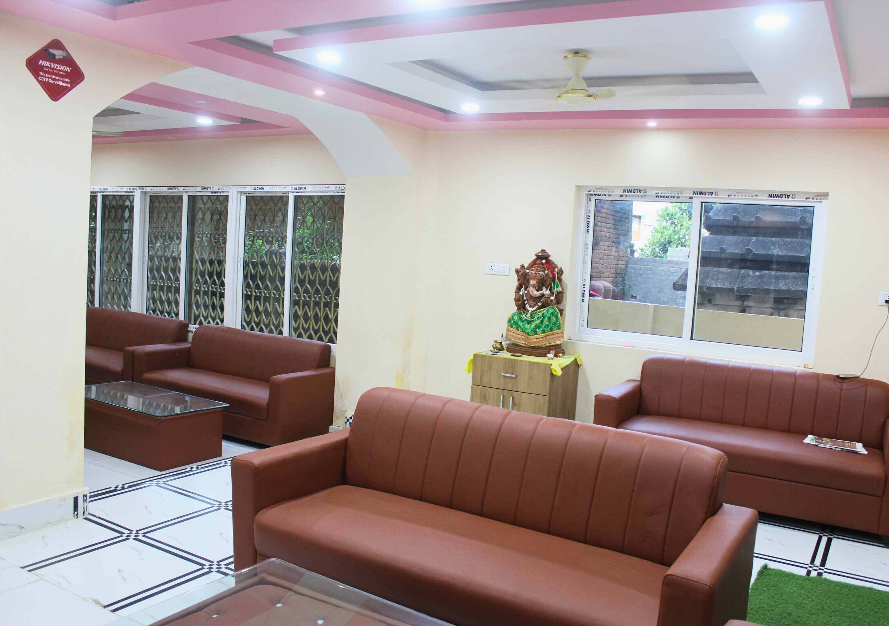 A living room with brown sofas, a glass coffee table, and a decorative statue.