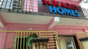 Un edificio de varios pisos con un letrero que dice 'SUKADAH HOMES'.