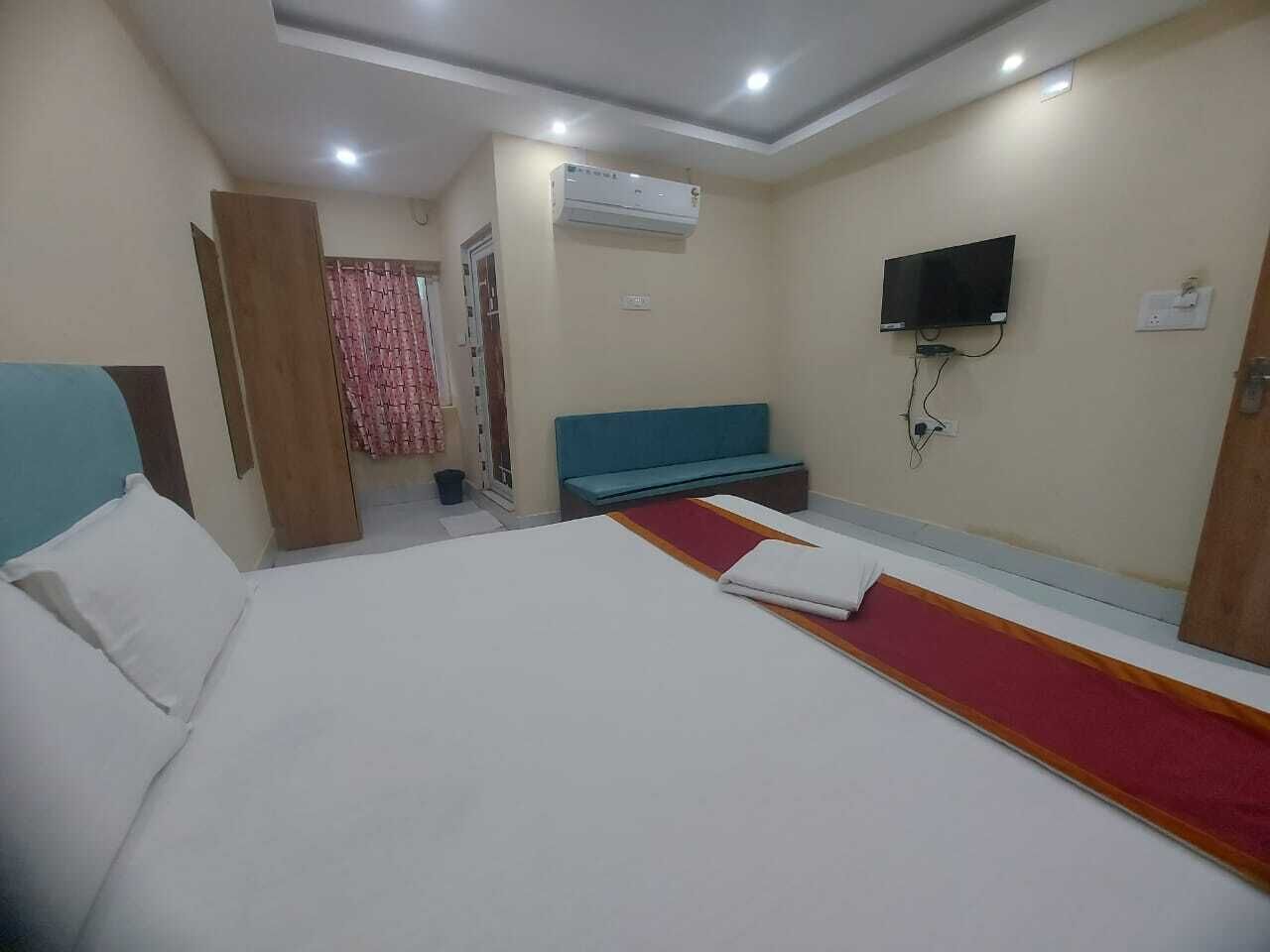 Une chambre d’hôtel équipée d’un lit, d’une télévision, d’un système de climatisation et d’un espace douche.