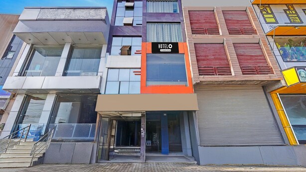 Un hotel de varios pisos con un llamativo letrero 'HOTEL', grandes ventanales y un estilo arquitectónico moderno.