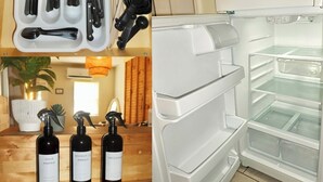 A kitchen with a white refrigerator, a set of utensils in a container, and three wine bottles on a wooden surface. - LUXURY DOWNTOWN COLUMBUS TOWNHOME (Columbus)