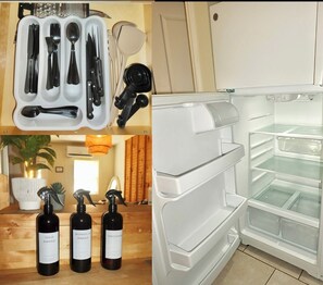A kitchen with a white refrigerator, a set of utensils in a container, and three wine bottles on a wooden surface. - LUXURY DOWNTOWN COLUMBUS TOWNHOME (Columbus)