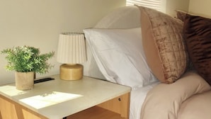 A bedroom with a bed, bedside table, lamp, and a potted plant. - LUXURY DOWNTOWN COLUMBUS TOWNHOME (Columbus)