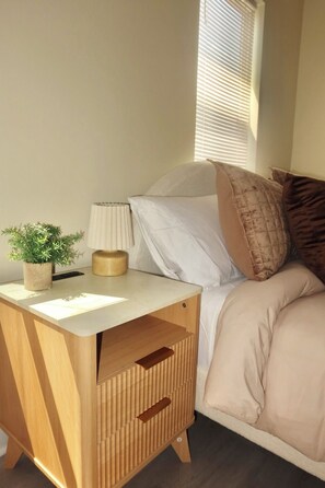 A bedroom with a bed, bedside table, lamp, and a potted plant. - LUXURY DOWNTOWN COLUMBUS TOWNHOME (Columbus)