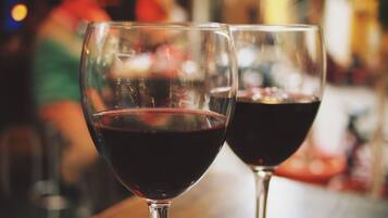 Dos copas de vino tinto sobre una barra.