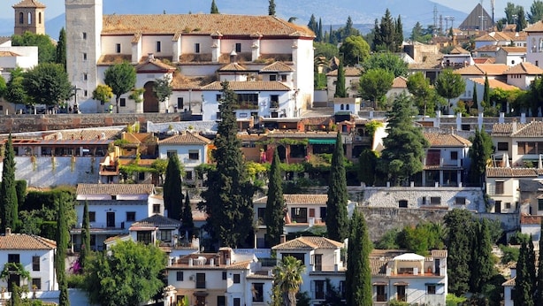 A coastal town with traditional architecture, including a prominent tower and terraced buildings. - Siloe Plaza Apartments (Granada)
