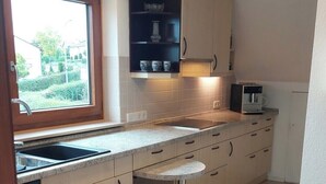 Eine moderne Küche mit Backofen, Spüle und Fenster.