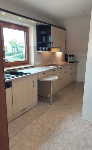 Eine moderne Küche mit Backofen, Spüle und Fenster.