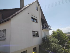 A two-story building with a balcony, windows, and a door. - Cozy vacation rental for up to 6 people with a balcony in the "Swabian Tuscany" region (Mühlacker)
