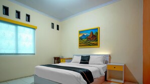 Ein Schlafzimmer mit einem Bett, einem Nachttisch, einem Fenster mit Jalousien und einem Bild an der Wand.
