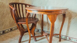 Un juego de mesa y silla de madera frente a una pared de azulejos.