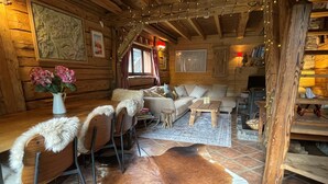 Ein gemütliches Blockhaus-Interieur mit Essbereich, Sofa und Kamin.