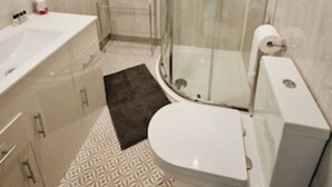 Un baño con ducha, inodoro y lavamanos.