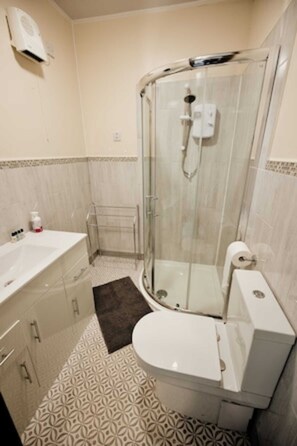 Ein Badezimmer mit Dusche, Toilette und Waschbecken.