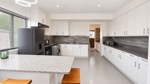 Una cocina moderna con gabinetes blancos, encimera de granito y horno empotrado.