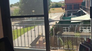 A room with a large window, a table, and a chair.