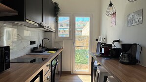 Eine moderne Küche mit Einbauherd, einer Kaffeemaschine und Blick ins Freie.