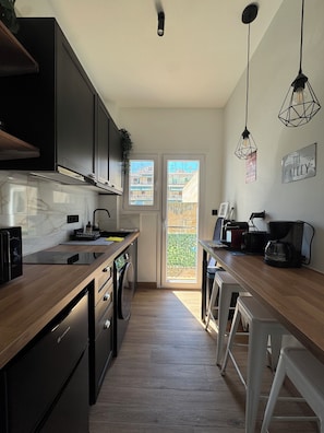A modern kitchen with a built-in stove, a coffee machine, and a view of the outside. - The Aviator Experience Athens (Athina)