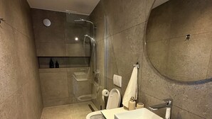 Un baño moderno con ducha, inodoro y lavabo.