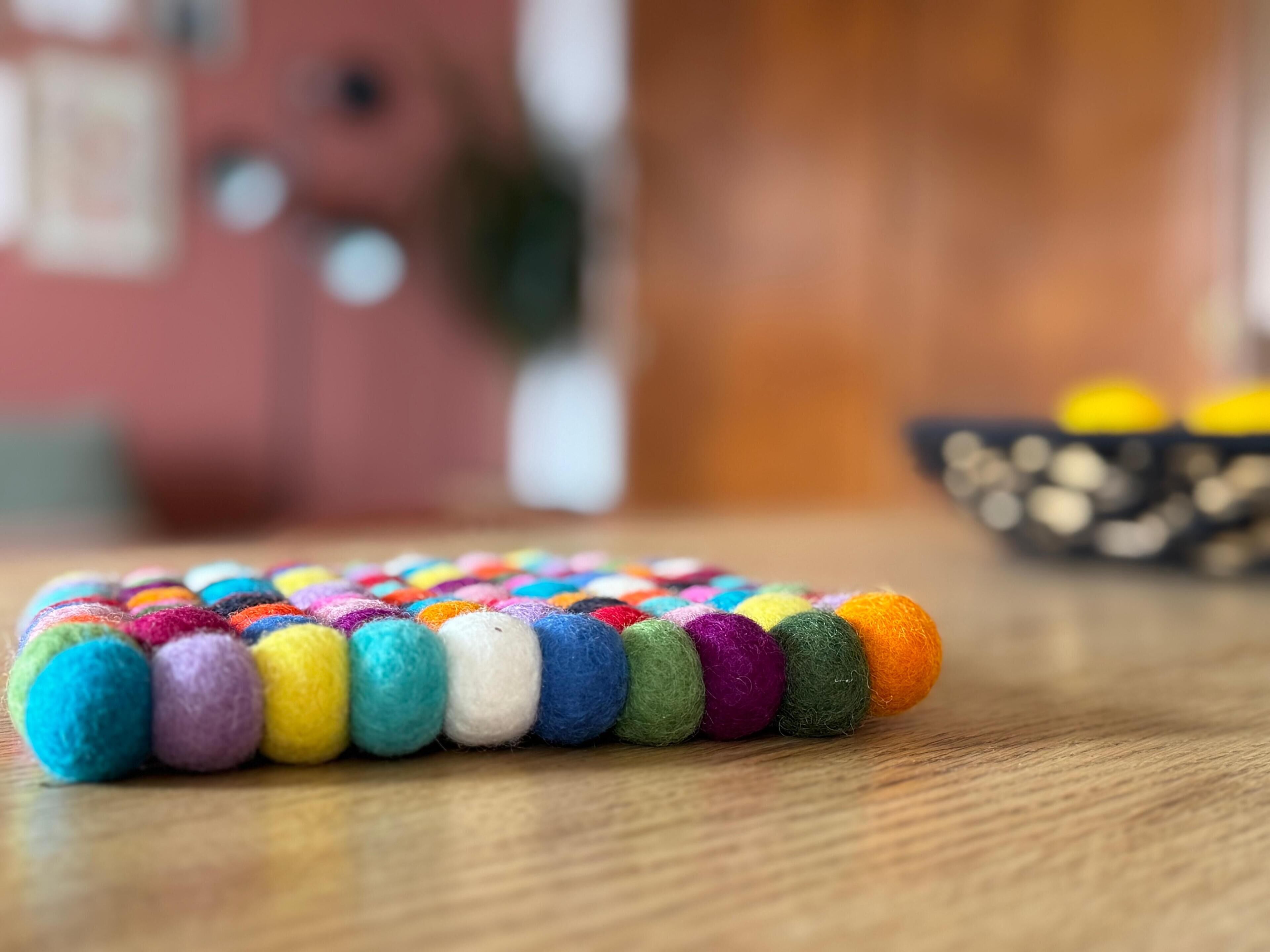 Un objeto colorido hecho con fieltro sobre una superficie de madera.