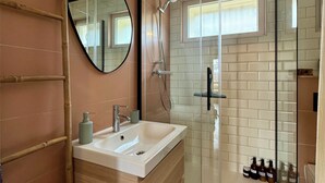 A bathroom with a wooden vanity, a mirror, a glass shower enclosure, and a small window. - "SIGI" Cozy apartment at the foot of the Ceüse cliff (Sigoyer)