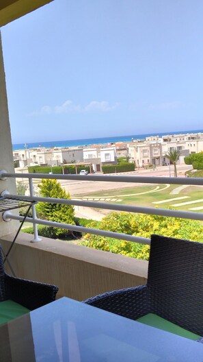 A balcony with a view of a residential area, a clear sky, and a distant body of water. - Delightful 2-bedroom chalet with Sea View in Amwaj (Marsa Matrouh Governorate)