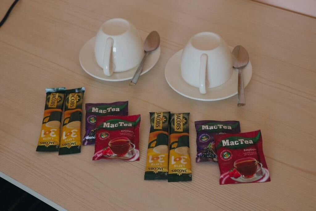 Ein Tisch mit zwei weißen Tassen und Löffeln sowie mehreren MacTea Teebeuteln.