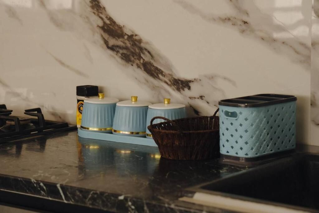 A kitchen counter with a marble backsplash, a gas stove, and kitchen appliances.