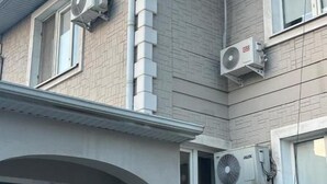 Un edificio de dos pisos con unidades de aire acondicionado instaladas en las paredes exteriores.