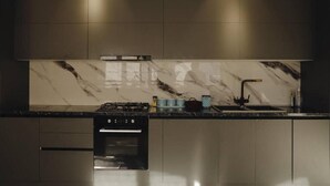 Una cocina moderna con horno empotrado, cocina a gas y un lavamanos.
