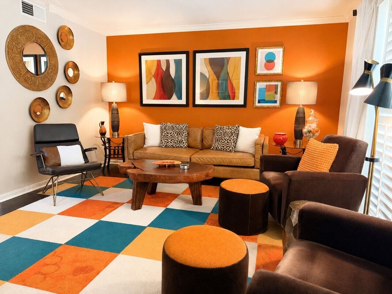 A living room with a sofa, armchairs, a coffee table, and a patterned rug.