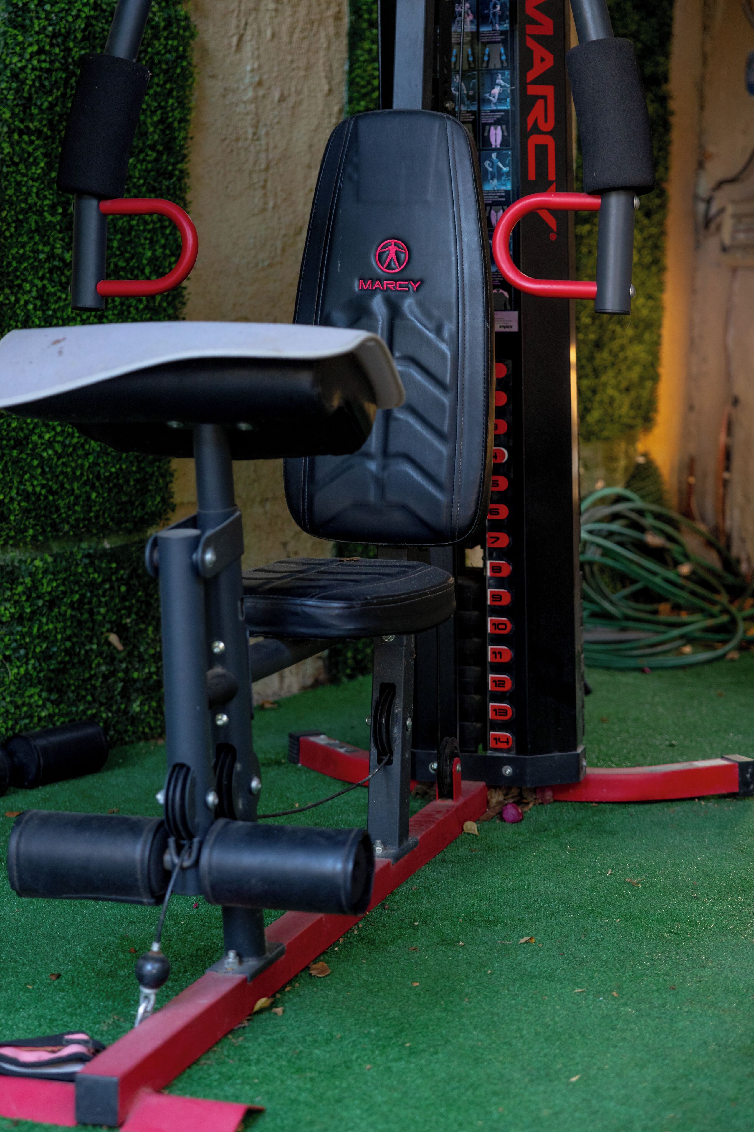 A stationary exercise machine with a seat and handlebars, positioned on artificial turf.