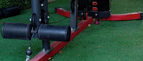 A stationary exercise machine with a seat and handlebars, positioned on artificial turf.