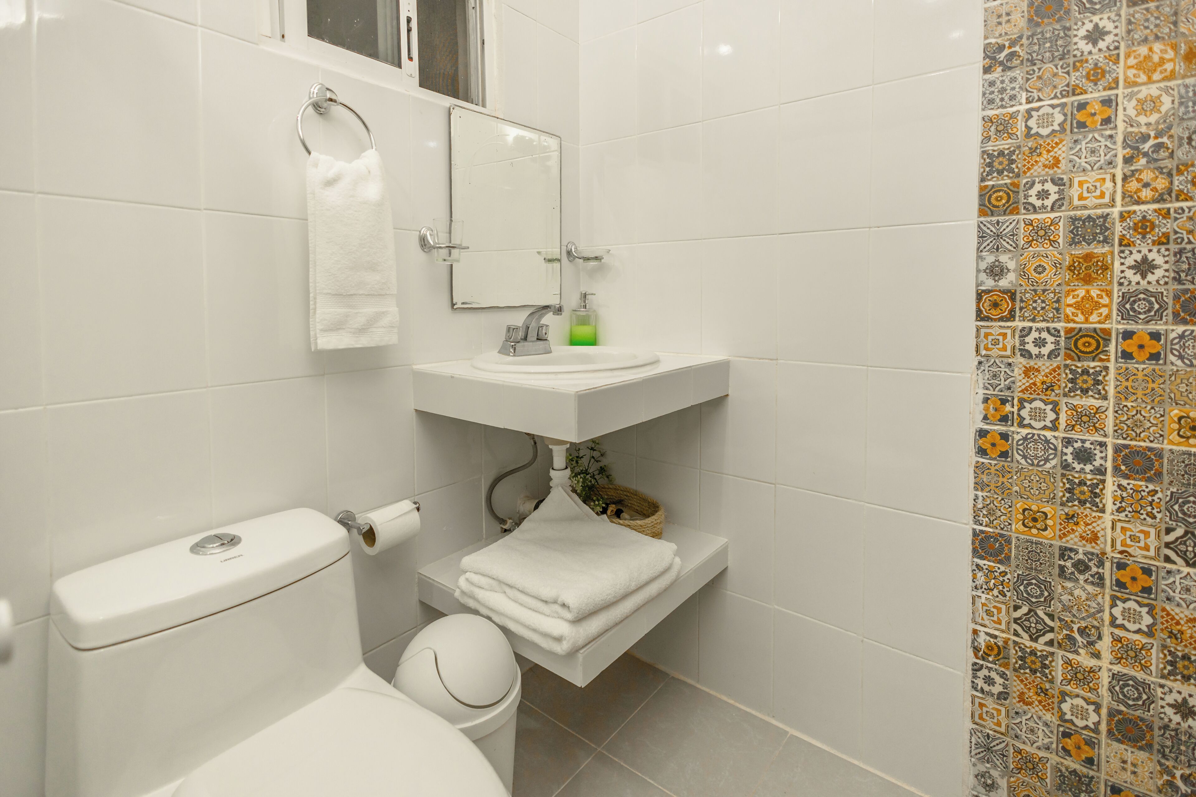 Un baño con inodoro, lavabo y espejo.
