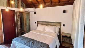 A bedroom with a wooden ceiling, a bed with white bedding, and a nightstand. - Recanto Due Fratelli (Passo de Torres)
